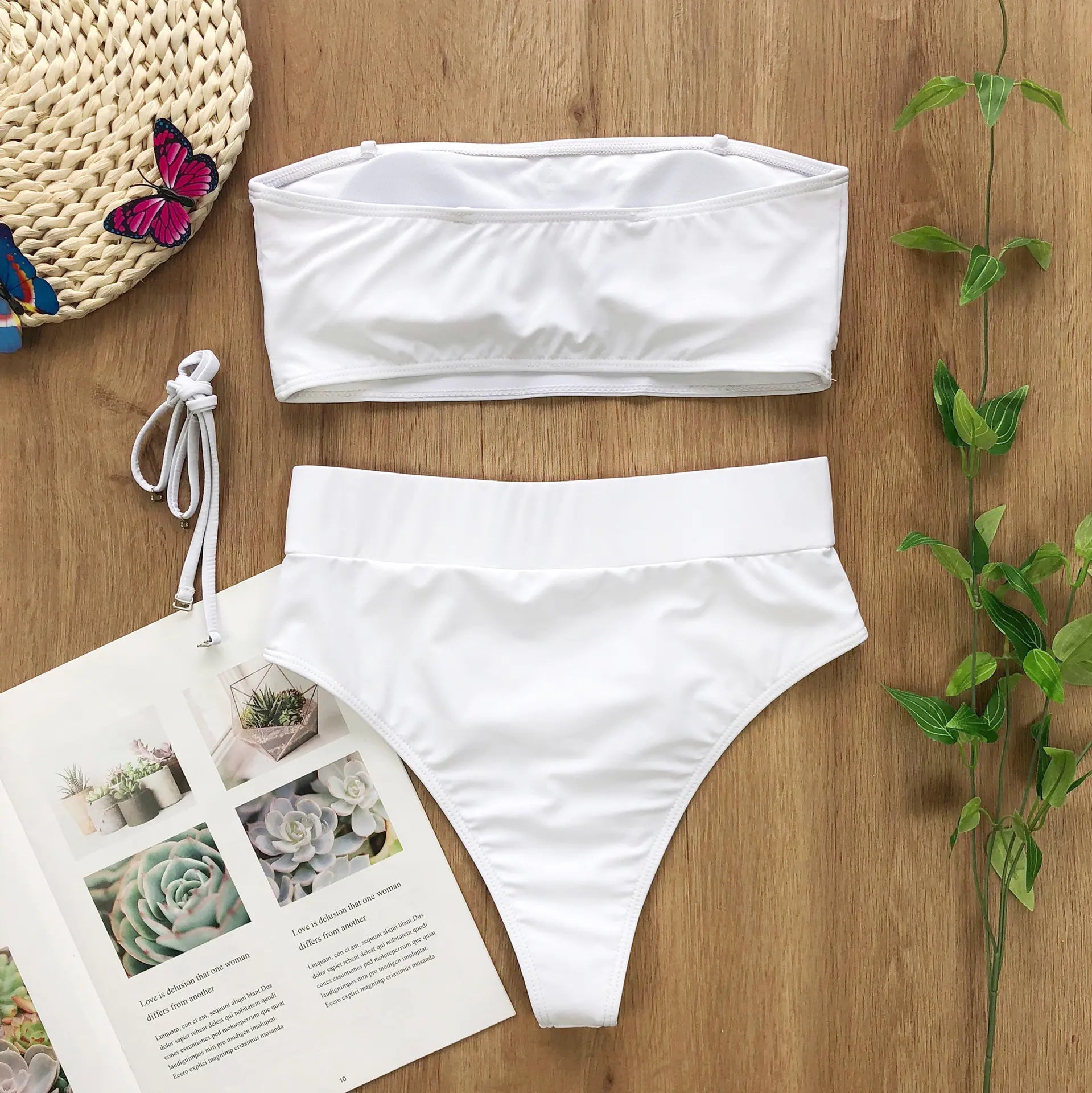 White bandeau bikini top and high-waist bikini bottoms set with side tie.