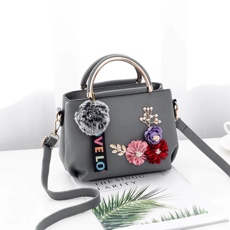 Gray leather shoulder bag with top handles, faux-fur pompom, floral applique and LOVE strap