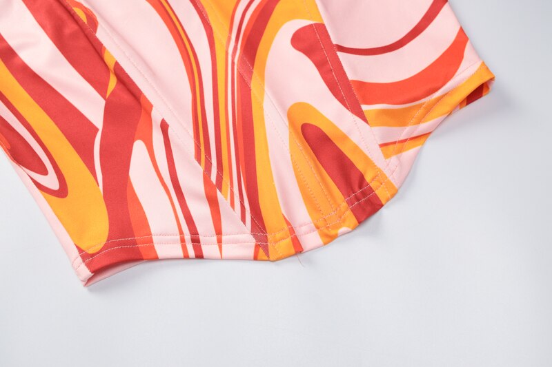 Close-up of swirl-printed hem and side seam on a mini dress