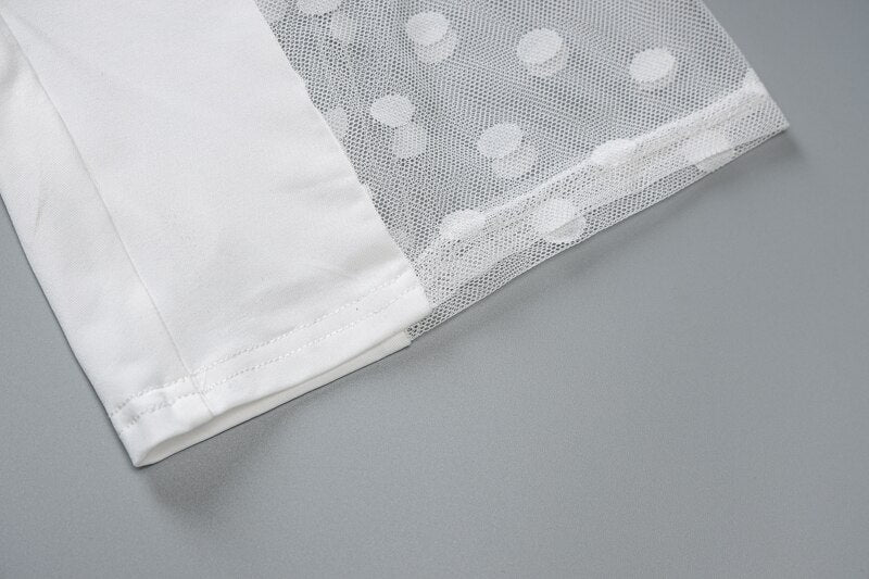 White bodysuit sleeve hem with sheer mesh overlay featuring subtle dot pattern