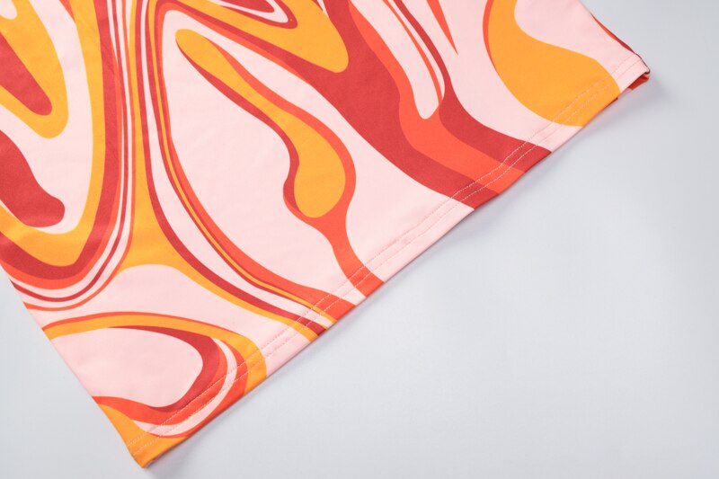 Printed garment fabric with abstract swirl pattern in pink, orange, red, and white