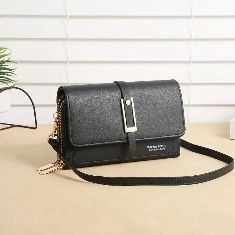 Black crossbody bag with front flap, gold buckle, and zipper charm