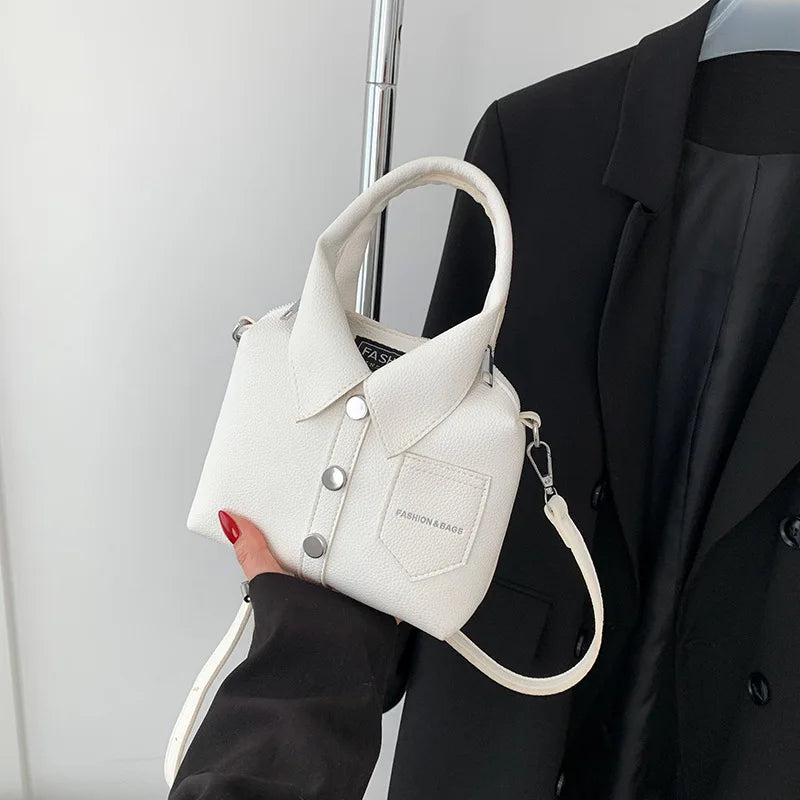 White mini handbag with top handle, wrist strap, button front, and side metal rings