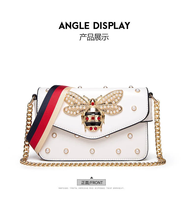 White front flap crossbody bag with striped strap, gold butterfly emblem and studs
