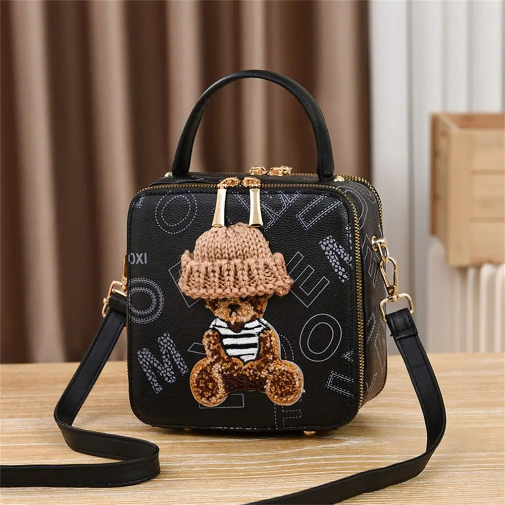 Black mini crossbody bag with adjustable strap, teddy applique and crochet beanie front