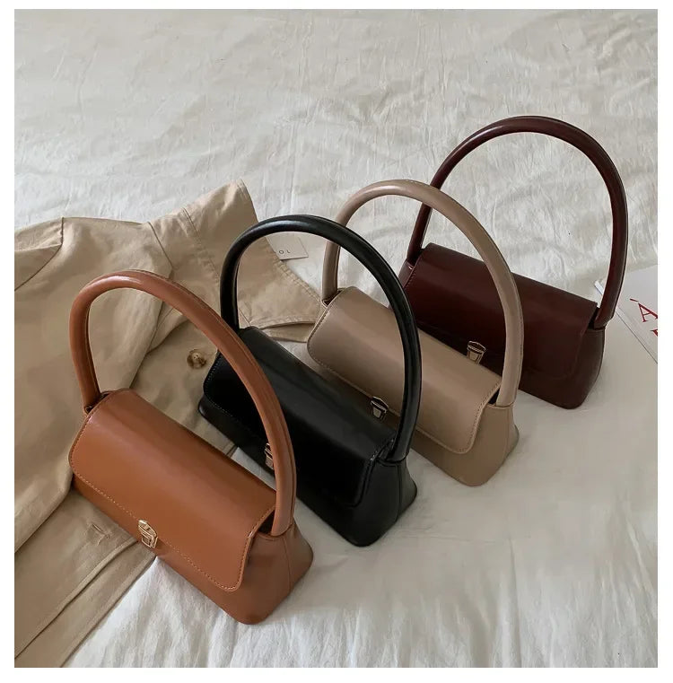 Set of top-handle handbags in black, tan, and brown with front clasp details