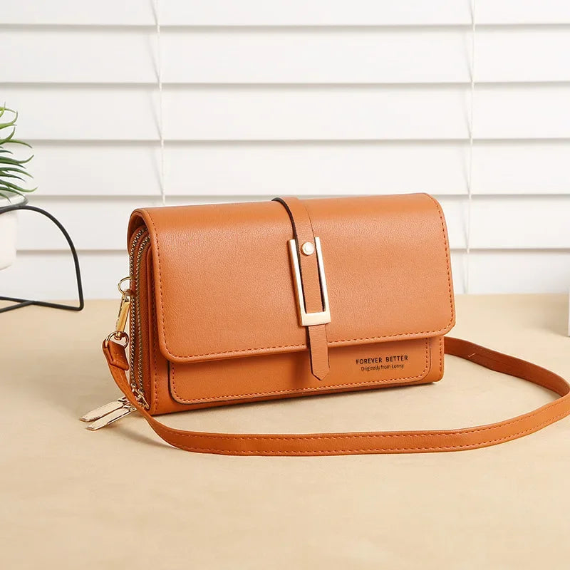 Tan-orange crossbody bag with front flap, gold buckle, and long shoulder strap