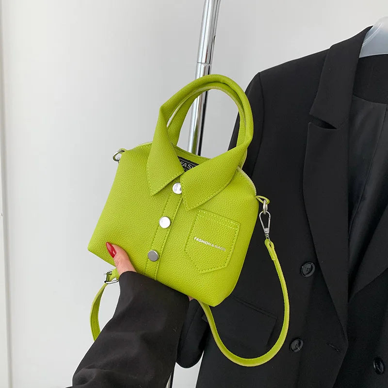 Green mini handbag with top handle, wrist strap, button front, and side metal rings