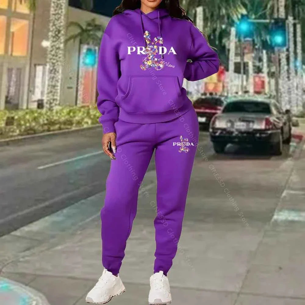 Women's 2-piece hoodie and jogger set, purple with PRADA logo on chest and pants.