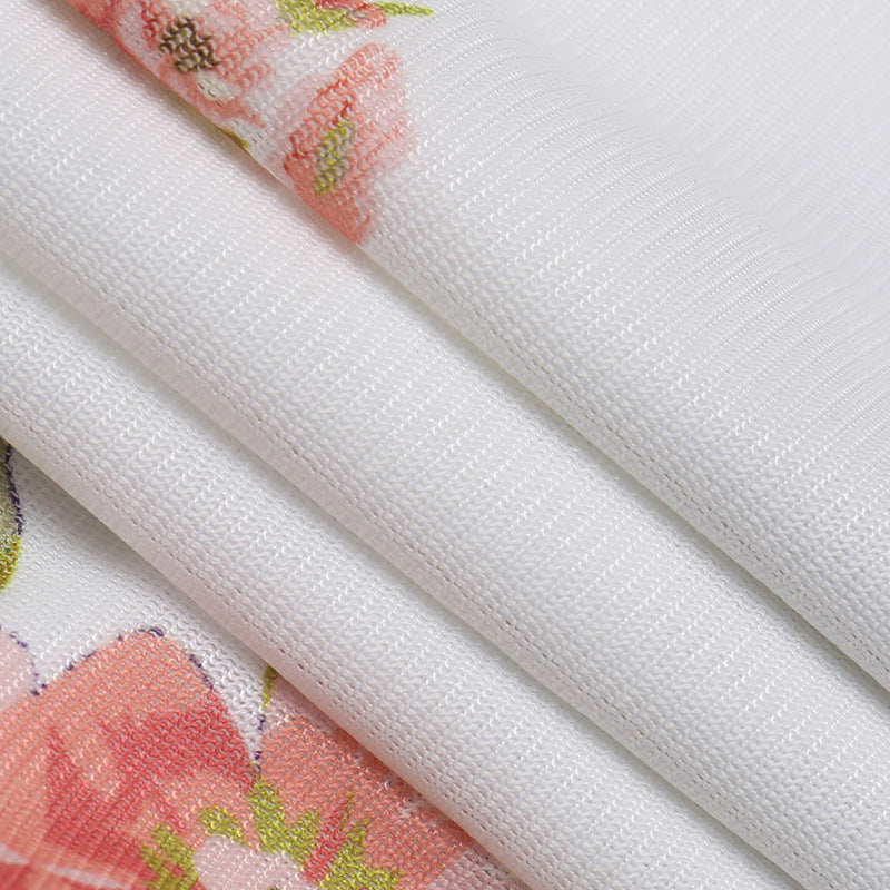 Floral slip dress close-up of white fabric with pink rose print and side seam