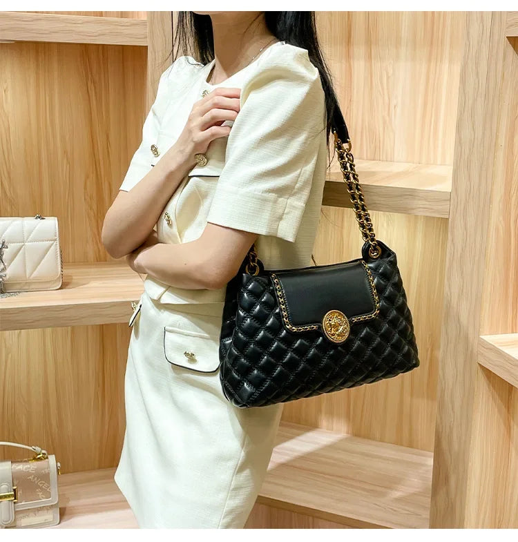 Black quilted shoulder bag with gold chain strap and round gold medallion front clasp