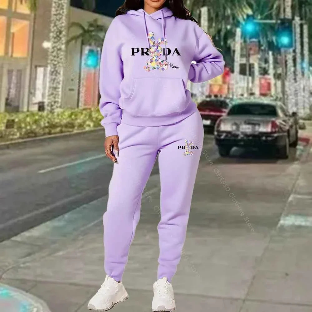 Women's 2-piece hoodie and jogger set, lavender purple with PRADA logo on chest and pants.