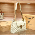 White quilted shoulder bag with gold chain strap, front flap, and round gold medallion clasp