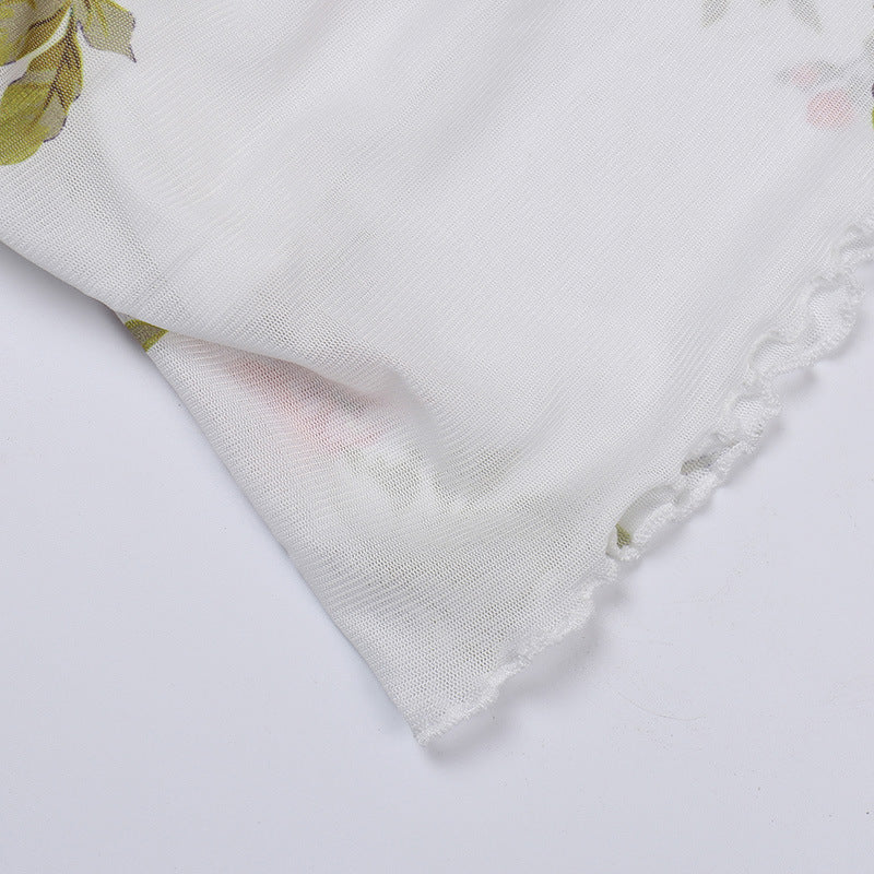 Floral slip dress hem close-up with white base and pink rose print, ruffled trim