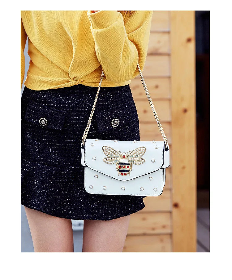White butterfly applique flap crossbody bag with gold studs and chain strap