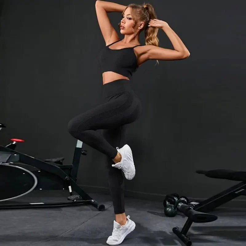 Black strappy sports bra and high-rise leggings set, one-leg lunge pose