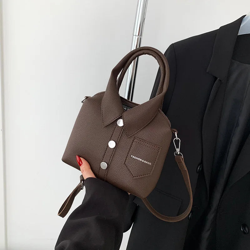 Brown mini handbag with top handle, wrist strap, button front, and side metal rings