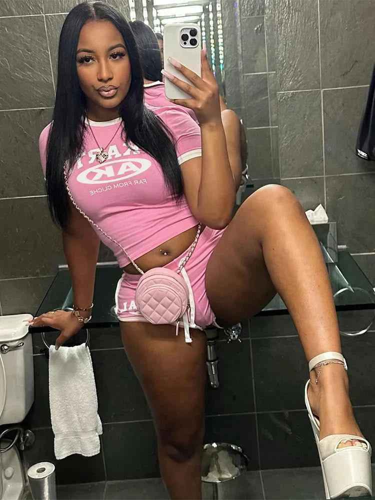 Pink cropped T-shirt and mini shorts set with white trim, KARTAL AK logo, crossbody bag.