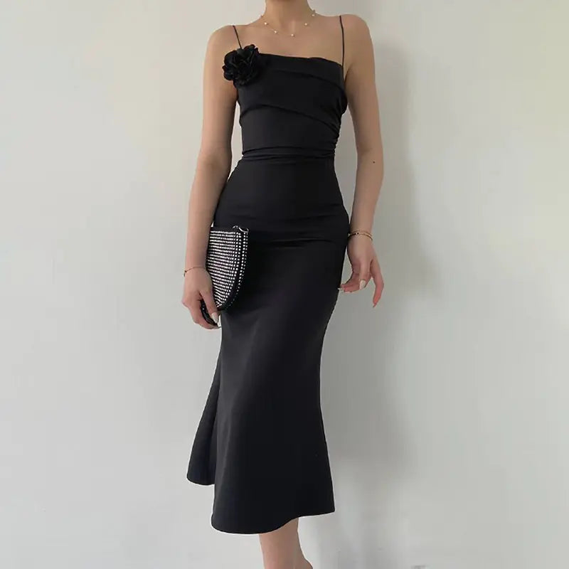 Black bodycon midi dress with thin straps, floral trim, side cutouts and flared hem