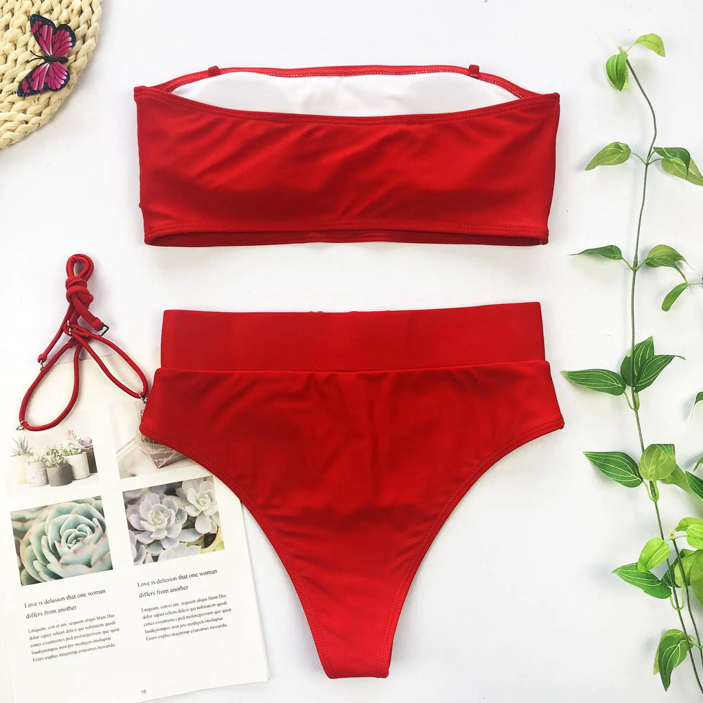 Red bandeau bikini top and high-waist bikini bottoms set, flat lay.
