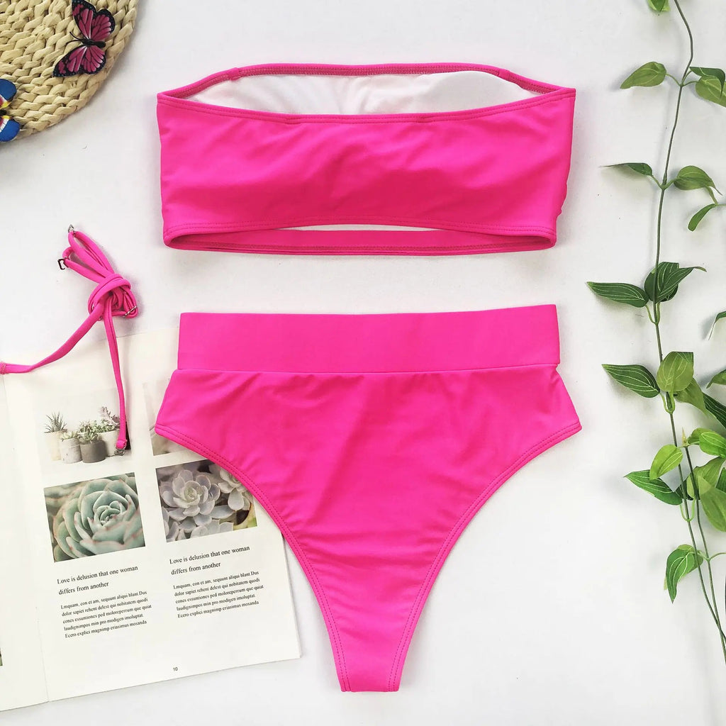 Hot pink bandeau bikini with high-waisted bottoms and gold medallion buckle